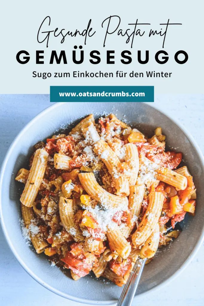 Gesunde Vollkornpasta mit Gemüsesugo in einem blauen Teller. Bestreut mit Parmesan. Löffel seitlich im Teller. Ansicht von oben.