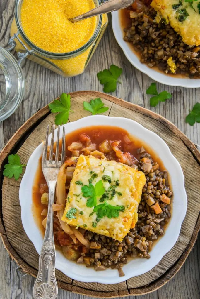 Überbackene Polentaschnitten auf Berglinsen und Fenchel-Tomatengemüse