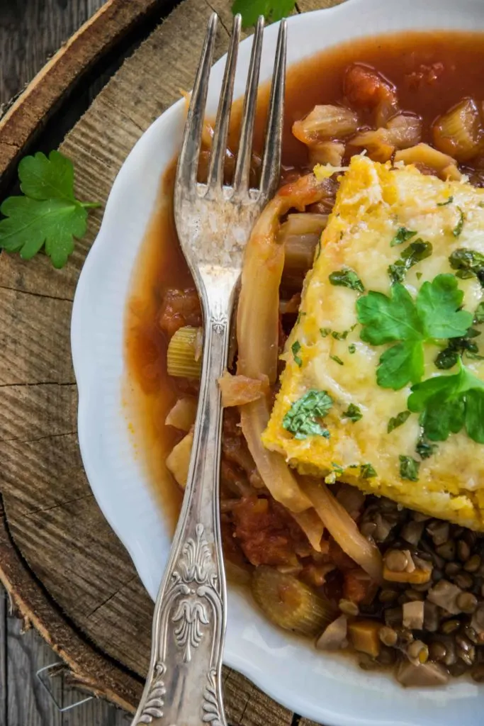 Überbackene Polentaschnitten auf Berglinsen und Fenchel-Tomatengemüse