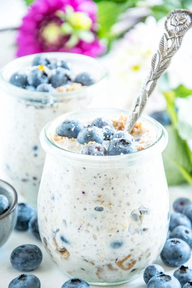 Blueberry Cheesecake Overnight Oats mit Vollkornbutterkeksen, Frischkäse, Zitrone, Ahornsirup und Heidelbeeren