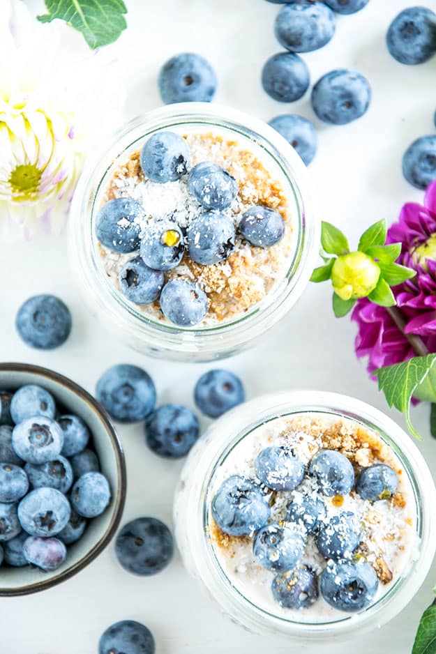 Blueberry Cheesecake Overnight Oats mit Vollkornbutterkeksen, Frischkäse, Zitrone, Ahornsirup und Heidelbeeren