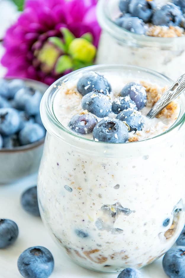 Blueberry Cheesecake Overnight Oats mit Vollkornbutterkeksen, Frischkäse, Zitrone, Ahornsirup und Heidelbeeren