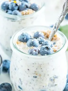 Blueberry Cheesecake Overnight Oats mit Vollkornbutterkeksen, Frischkäse, Zitrone, Ahornsirup und Heidelbeeren