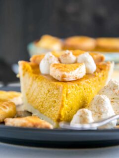 Ein Stück Pumpkin Pie mit Herbstblätter-Deko und Zimt-Sahne