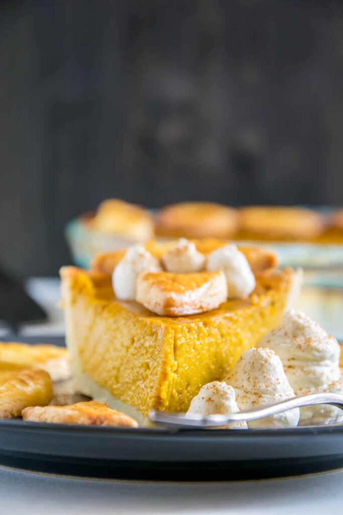 Ein Stück Pumpkin Pie mit Herbstblätter-Deko und Zimt-Sahne