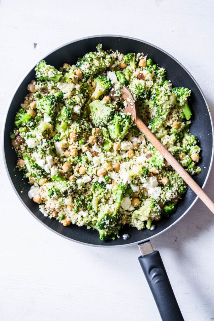 Grüne Couscous-Kichererbsenpfanne mit Feta, Pinienkernen, Brokkoli, Erbsen und Rosinen