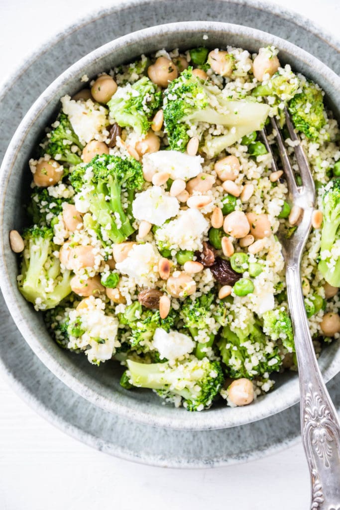 Grüne Couscous-Kichererbsenpfanne mit Feta, Pinienkernen, Brokkoli, Erbsen und Rosinen