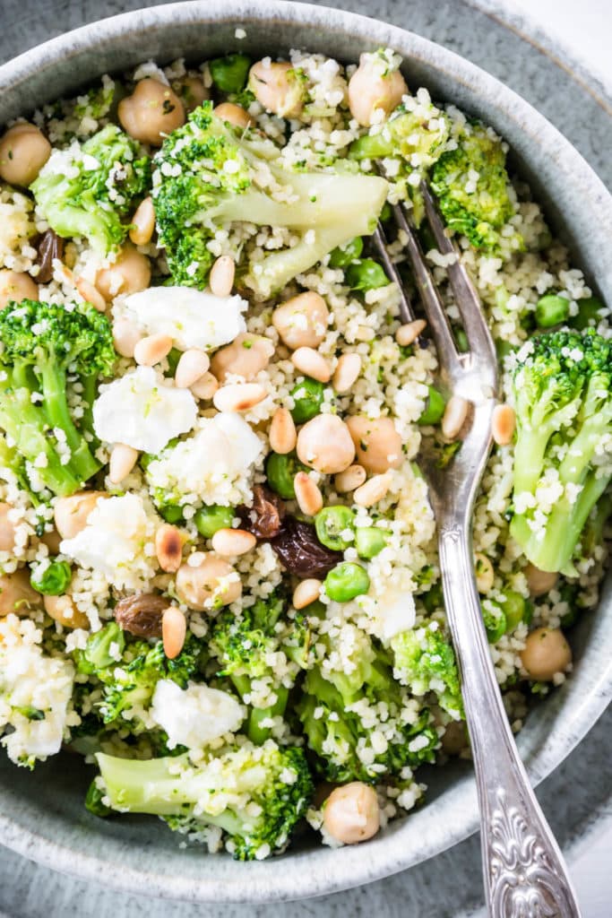 Grüne Couscous-Kichererbsenpfanne mit Feta, Pinienkernen, Brokkoli, Erbsen und Rosinen