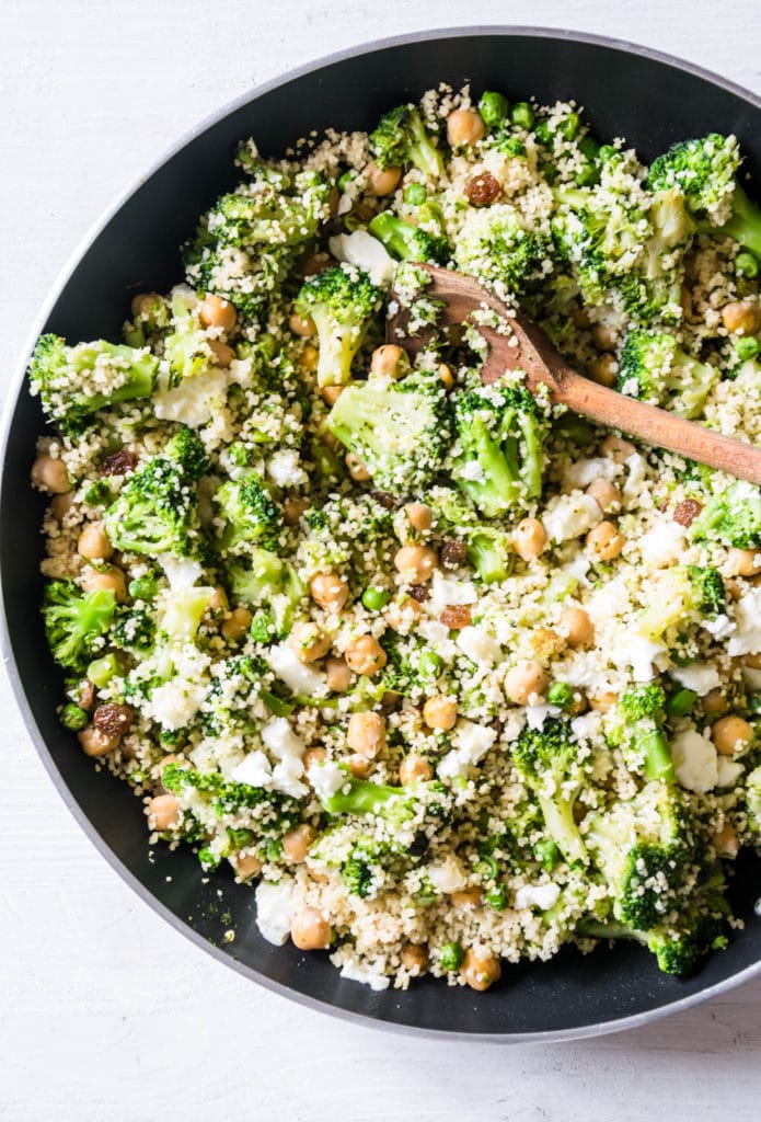 Grüne Couscous-Kichererbsenpfanne mit Feta, Pinienkernen, Brokkoli, Erbsen und Rosinen