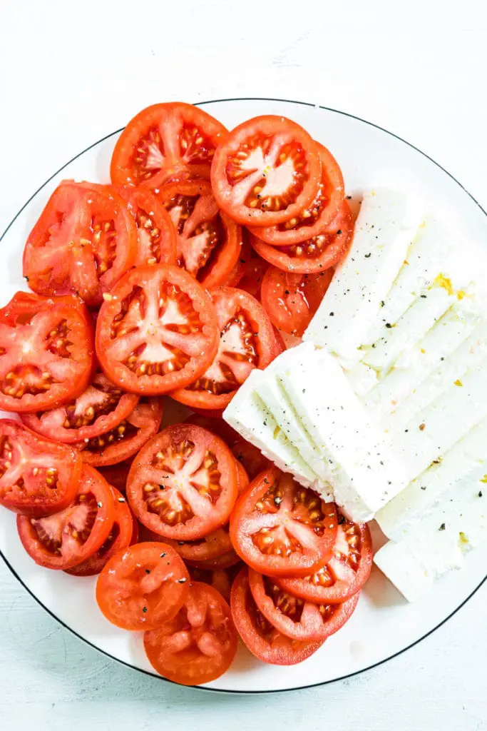 Tomatenscheiben und Feta für Polenta-Spinatgratin mit Feta