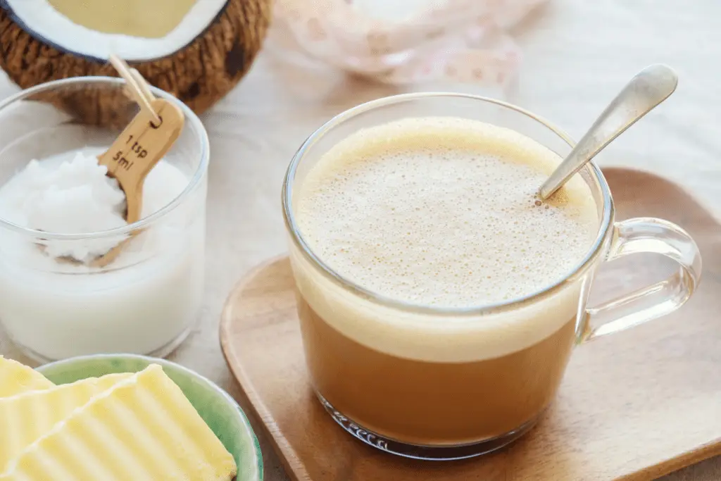 Ein Glas Bulletproof Coffee mit Butter, Kokosöl und Kokosnuss als Propst