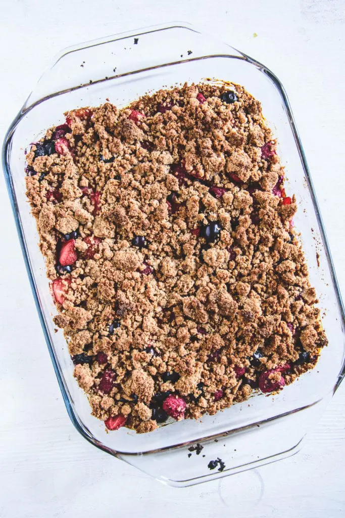 Gesunder Beeren-Streuselkuchen mit Dinkelmehl, Mandeln und ohne Zucker in einer Glasform. Ansicht von oben.