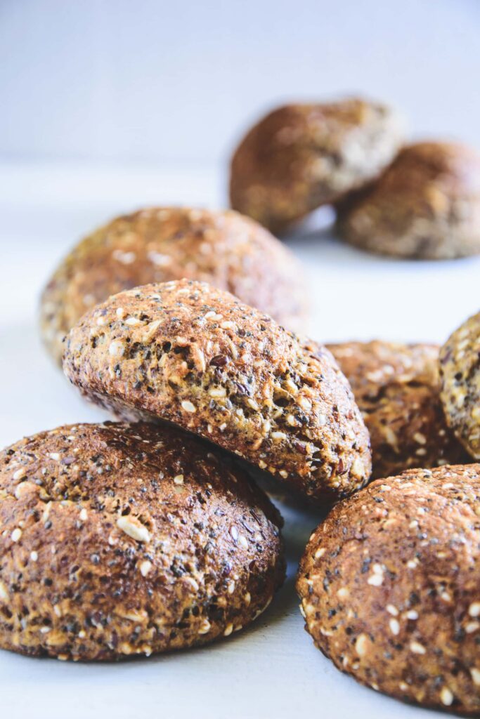 Schnelle Low Carb Saaten-Brötchen gestapelt auf weißem Hintergrund. 45-Grad-Winkel.