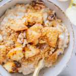 Cremiges Apfelstrudel-Porridge mit Zimtäpfeln, Rosinen und Butterbröseln.