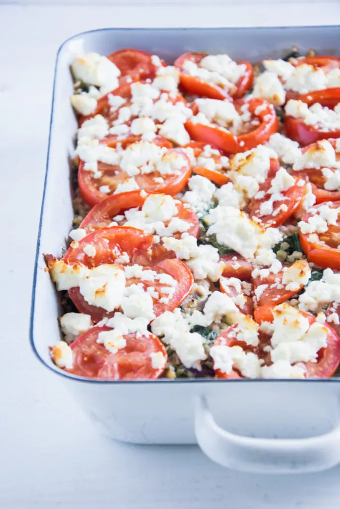 Gesunder Bulgur-Spinatauflauf mit Kichererbsen, Tomaten und Feta im 45-Grad-Winkel fotografiert.