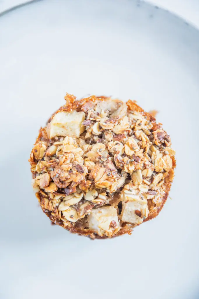 Oberfläche eines Oatmeal Muffins in der Nahaufnahme von oben auf einem blaugrauen Teller.