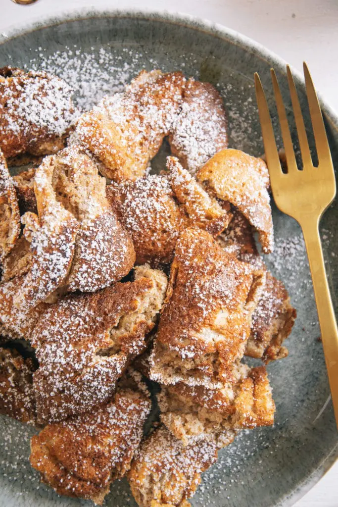 Nahaufnahme von Lebkuchen-Schmarrn mit goldener Gabel von oben.