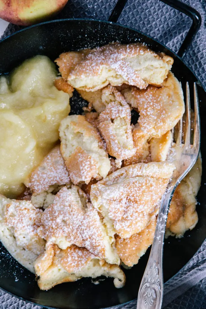 Nahaufnahme von oben: Protein-Kaiserschmarrn mit Apfelmus und silberner Gabel.