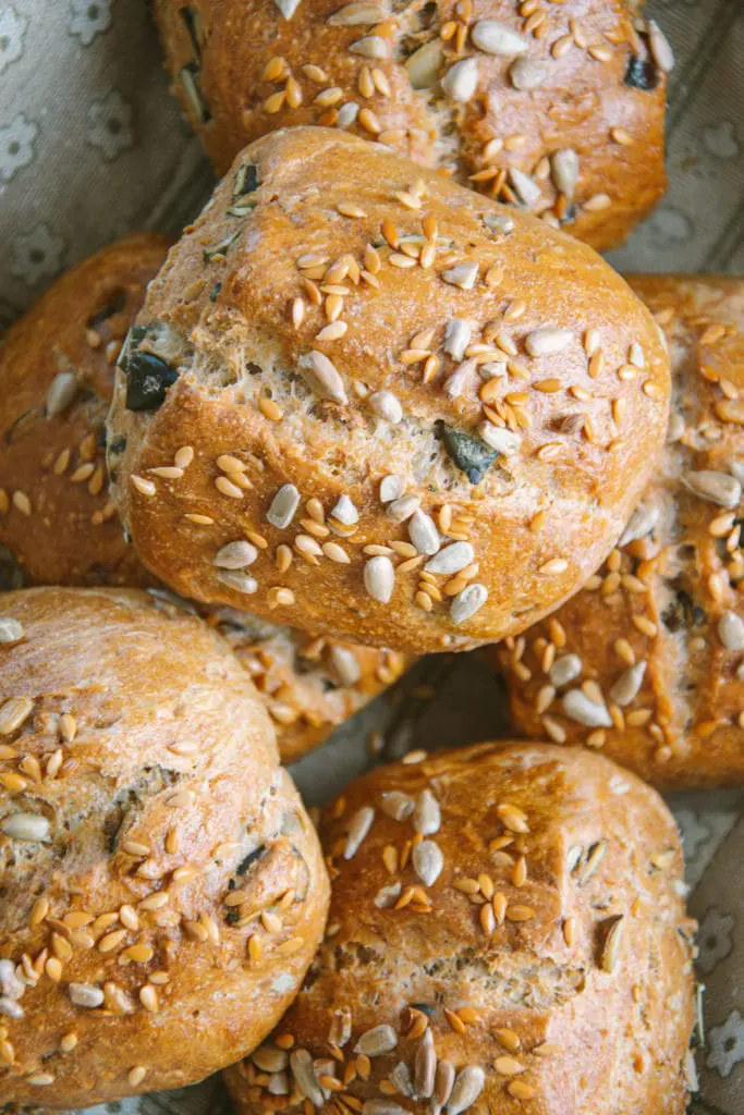 Nahaufnahme von knusprigen Dinkel-Körnerweckerln mit Übernachtgare von oben im Brotkorb.