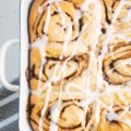 Nahaufnahme von oben von gesünderen Zimtschnecken mit Frischkäseglasur. Das schöne Muster der Schnecken und die Füllung sind deutlich erkennbar.