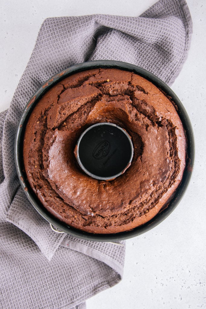 Der beste saftige Schokoladenkuchen in der Form von oben auf einem grauen Küchentuch fotografiert.