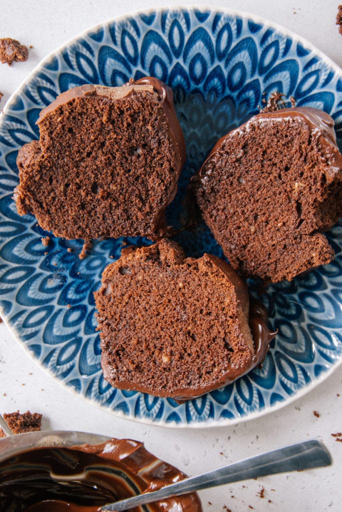 Drei Stücke saftiger Schokoladenkuchen von oben auf einem blauen Teller fotografiert.