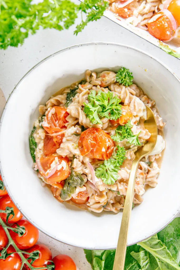 Nahaufnahme von veganer Baked Feto Pasta in einem tiefen Teller von oben, sodass die Cremigkeit und die verschiedenen Zutaten deutlich erkennbar sind.