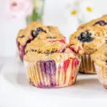Vegane zuckerfreie Beerenmuffins auf Augenhöhe auf einer weißen Tortenplatte fotografiert