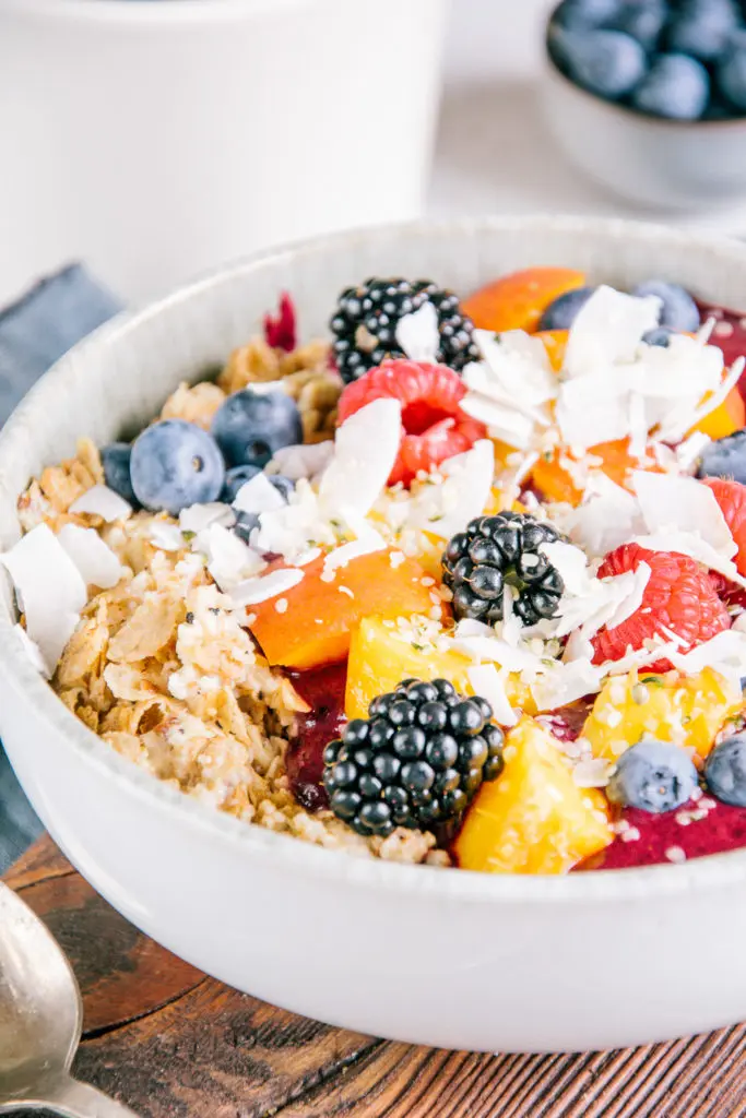 Porridge mit Nicecream im 45-Grad-Winkel aus der Nähe fotografiert, sodass die Details von Haferflocken und buntem Früchte-Topping deutlich erkennbar sind