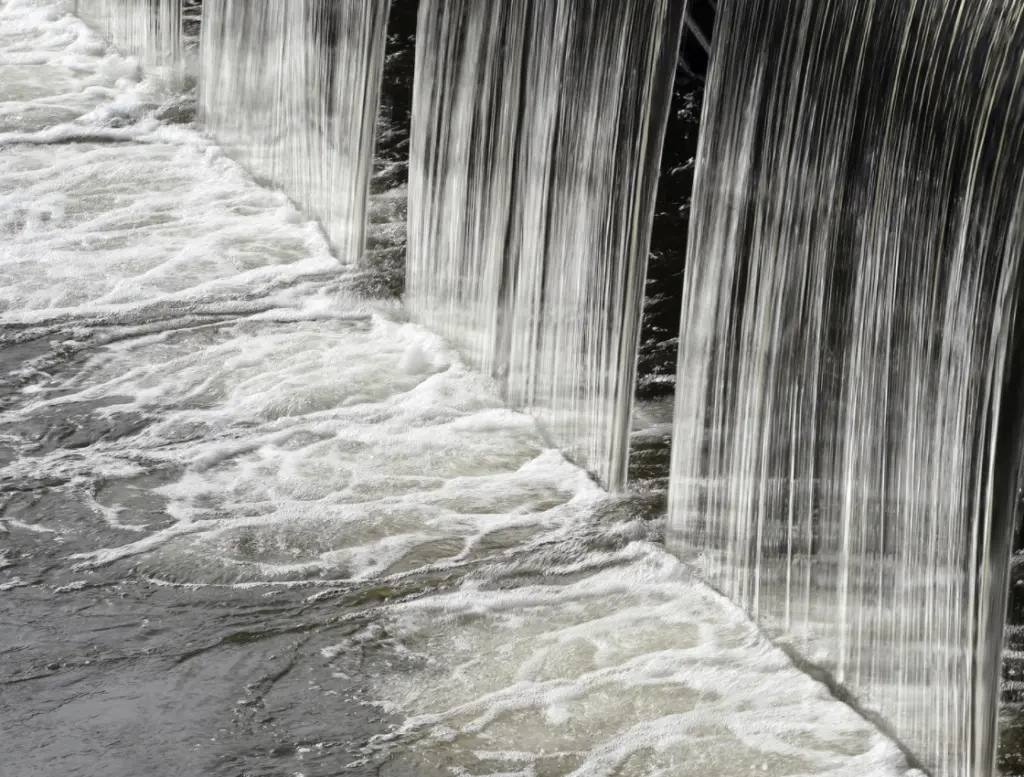 Wasser, das in dicken Strahlen von oben in ein Becken fließt