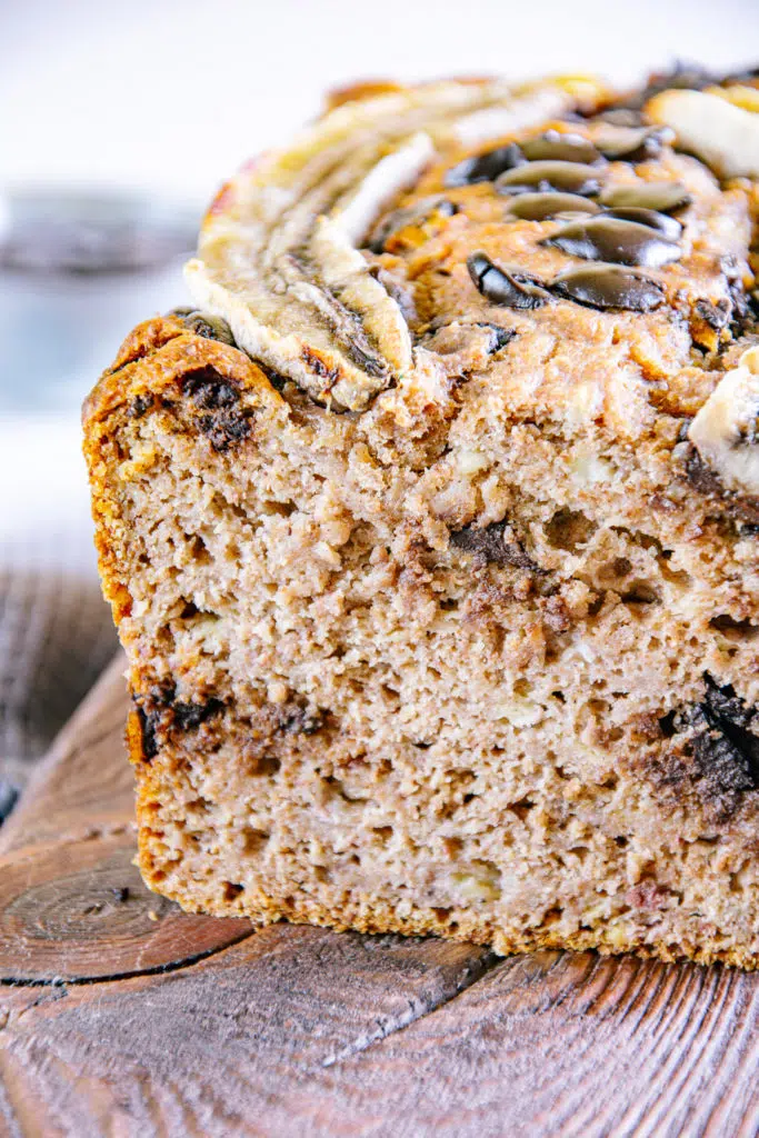 Nahaufnahme von gesundem veganen Chocolate Chip Bananenbrot in der Frontalansicht leicht von oben. Bild auf der rechten Seite angeschnitten.