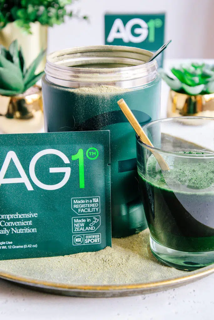 AG1-Metalldose mit Travel Pack und zubereitetem Drink in einem grünen Glas