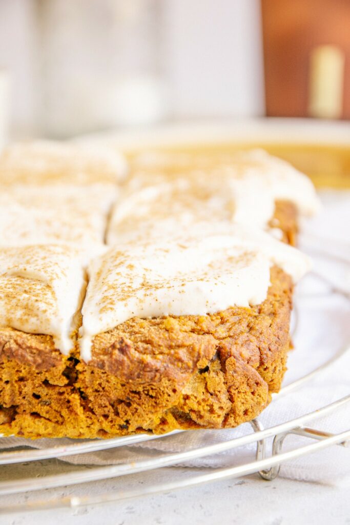 Veganer zuckerfreier Kürbiskuchen auf einem silbernen Kuchengitter und einem weißen Leinentuch