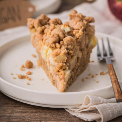 Frontalansicht von einem Stück veganen Streuselkuchen mit Äpfeln