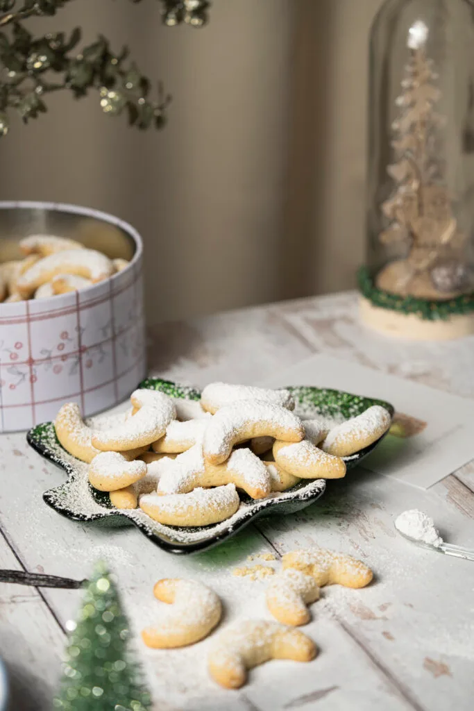 Vanillekipferl auf einem tannenbaumf&ouml;rmigen Keksteller aus Glas.