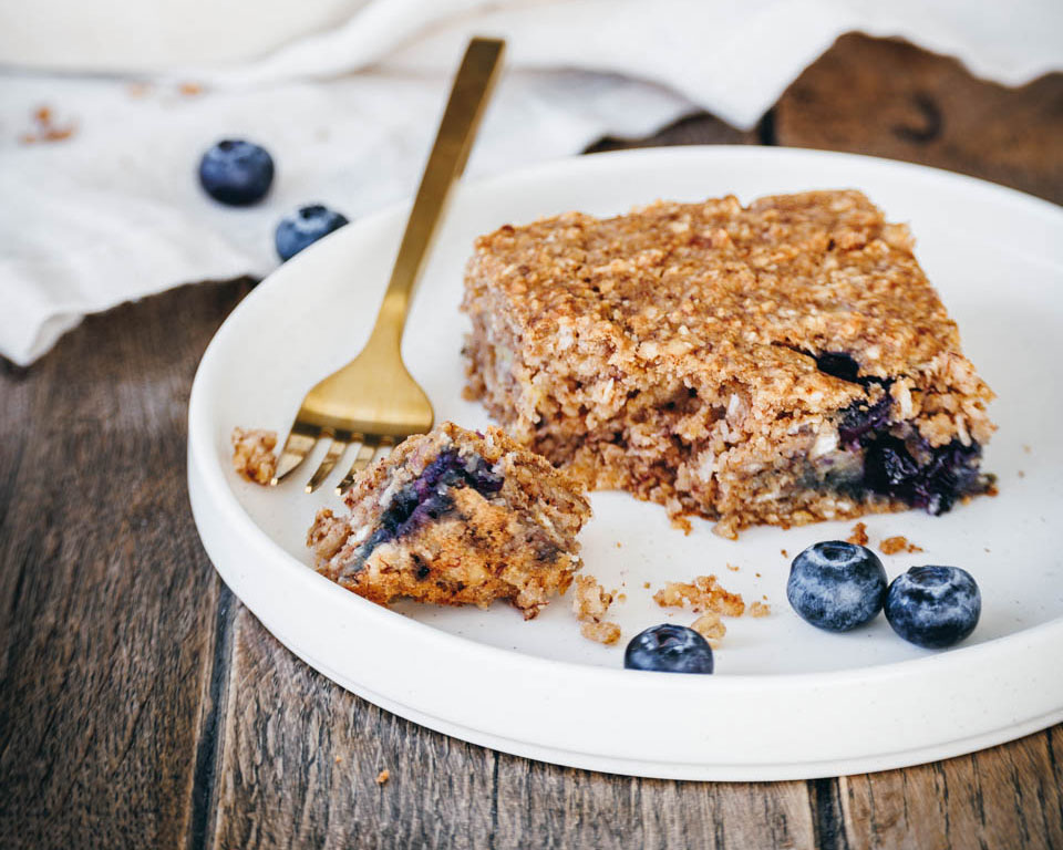 Ein Stück veganer Haferflocken-Kuchen ohne Zucker auf einem Teller.