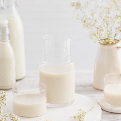 Karaffe und Glas mit Hafermilch.