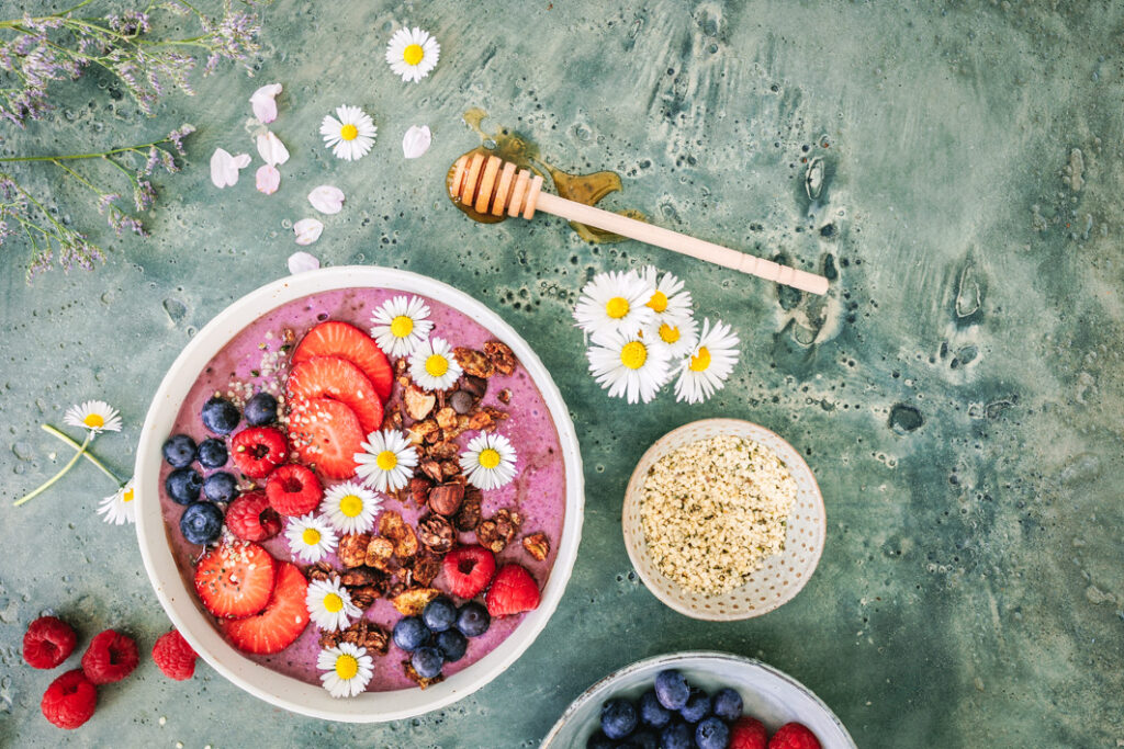 Beeren-Smoothie-Bowl mit Früchten und Schoko-Granola.