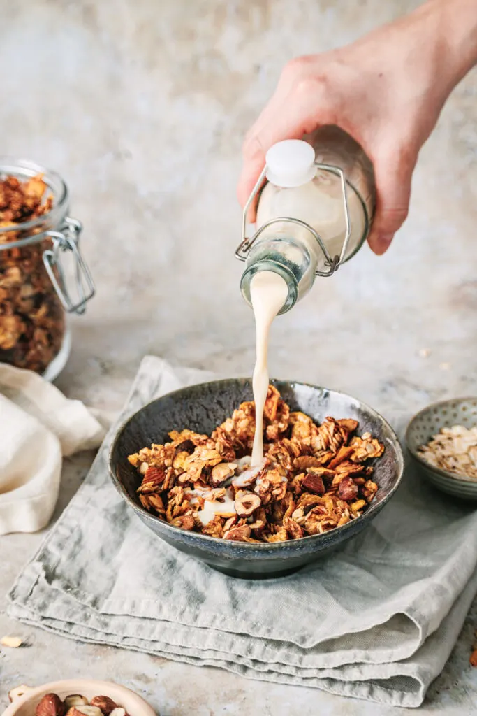 Knuspriges Granola ohne Zucker in einer Schüssel mit Hafermilch.