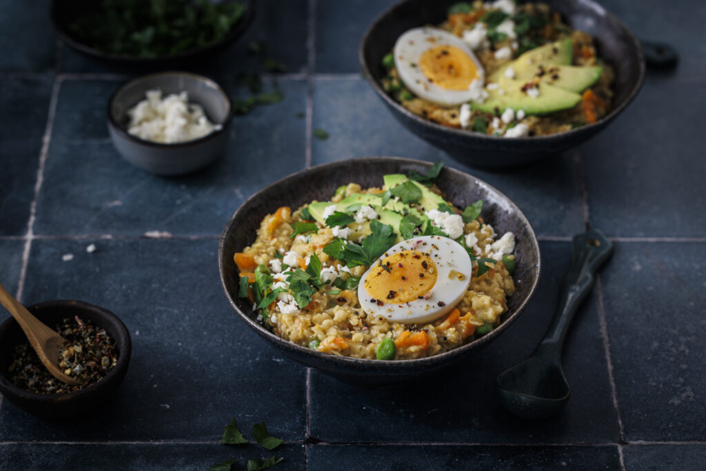 Deftiges Porridge mit Gemüse, Avocado, Ei und Feta.