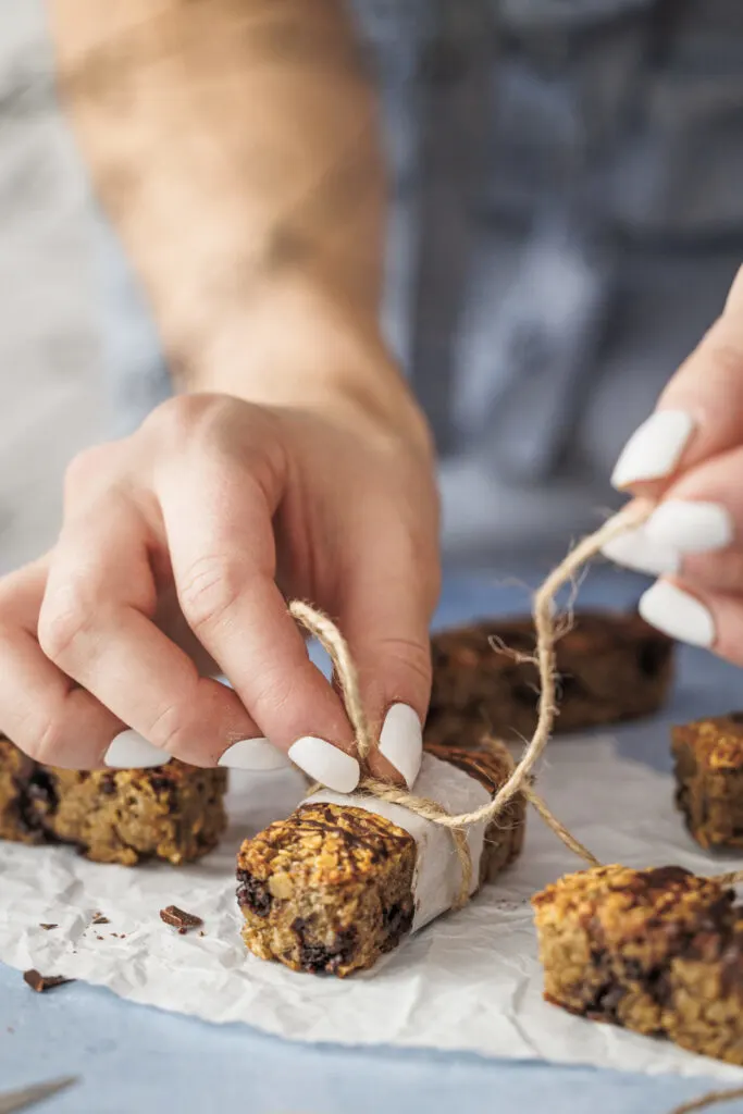 Haferriegel als gesunder Snack werden mit Backpapier-Manschetten verziert.