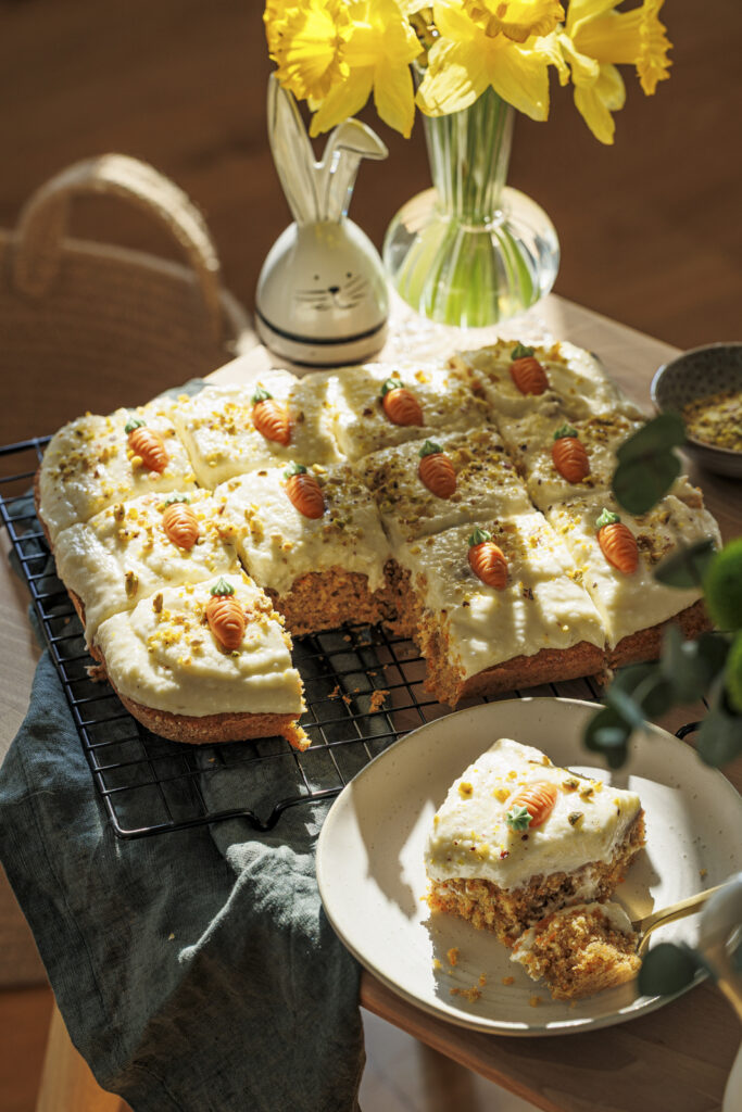 Flaumiger Karottenkuchen für Ostern – mit Cream Cheese Frosting, Pistazien und Marzipankarotten.