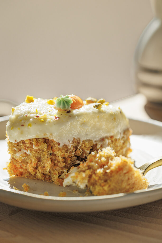 Close-Up von einem Stück saftigem Karottenkuchen mit Cream Cheese Frosting.