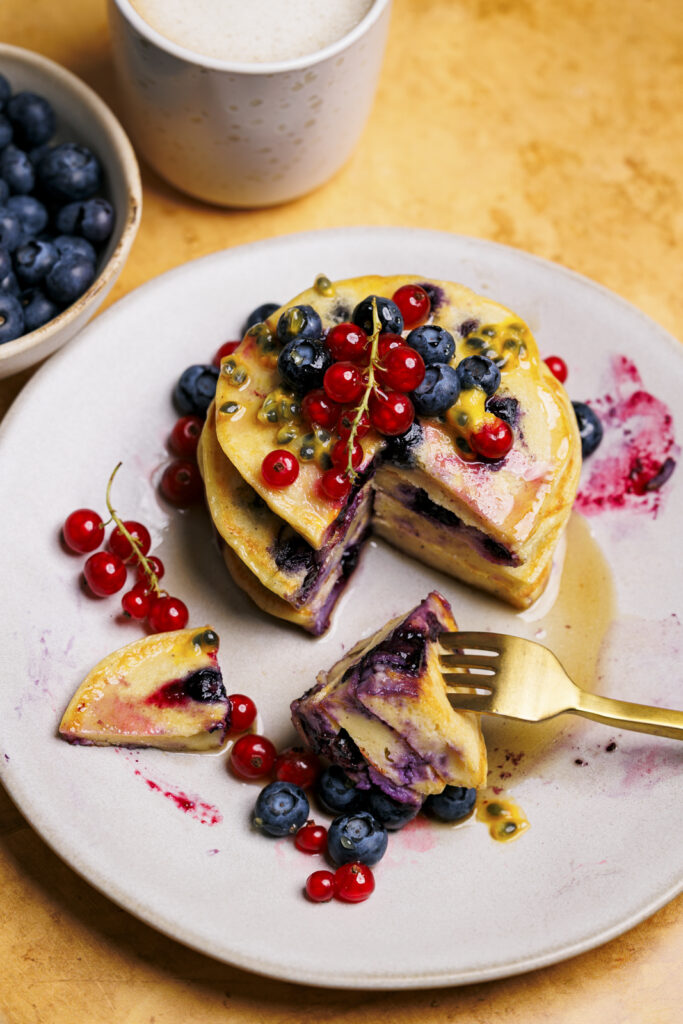 Protein-Blaubeer-Pancakes mit roten Johannisbeeren und Maracuja.