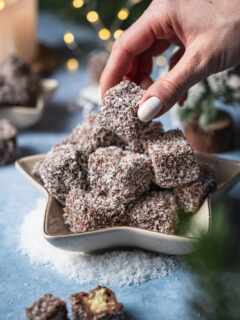 Raunigel in einer sternförmigen Schale. Hand nimmt den obersten Würfel weg.