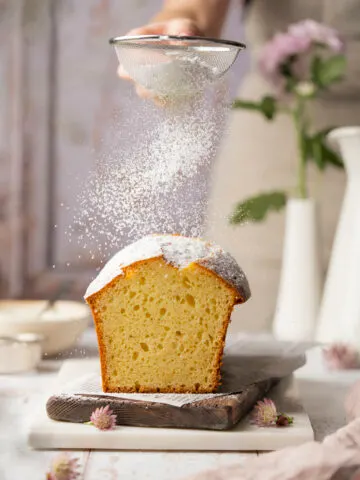 Joghurtkuchen wird mit Staubzucker bestreut.