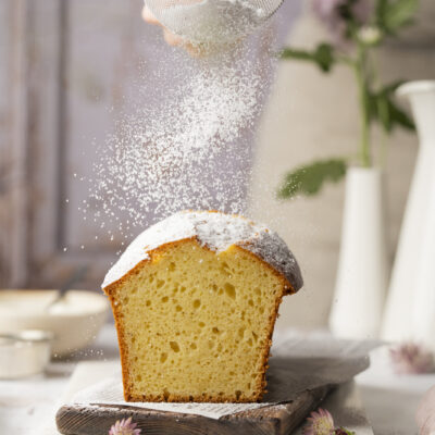 Joghurtkuchen wird mit Staubzucker bestreut.