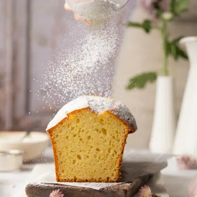 Joghurtkuchen wird mit Staubzucker bestreut.