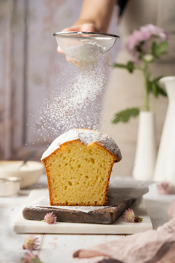 Joghurtkuchen wird mit Staubzucker bestreut.